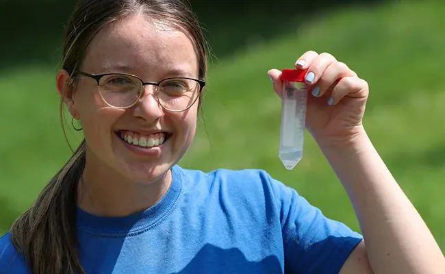 a biology student holds up a sample